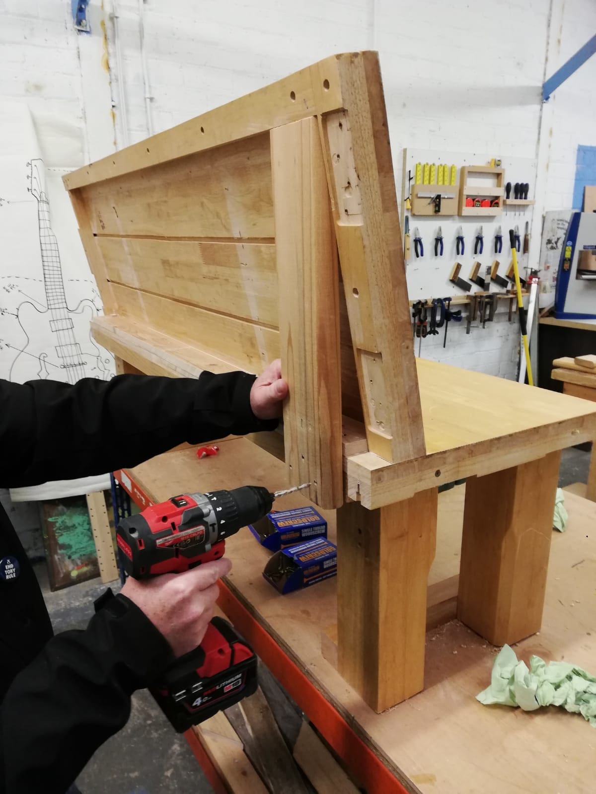 Man drilling into wooden bench